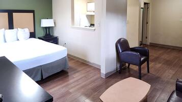 Una habitación de hotel con una cama, un escritorio, una silla y una mesita.