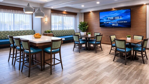 A modern hotel room with a dining area, a large flat-screen TV, and a wooden accent wall. - Best Western Cy-Fair (Houston)