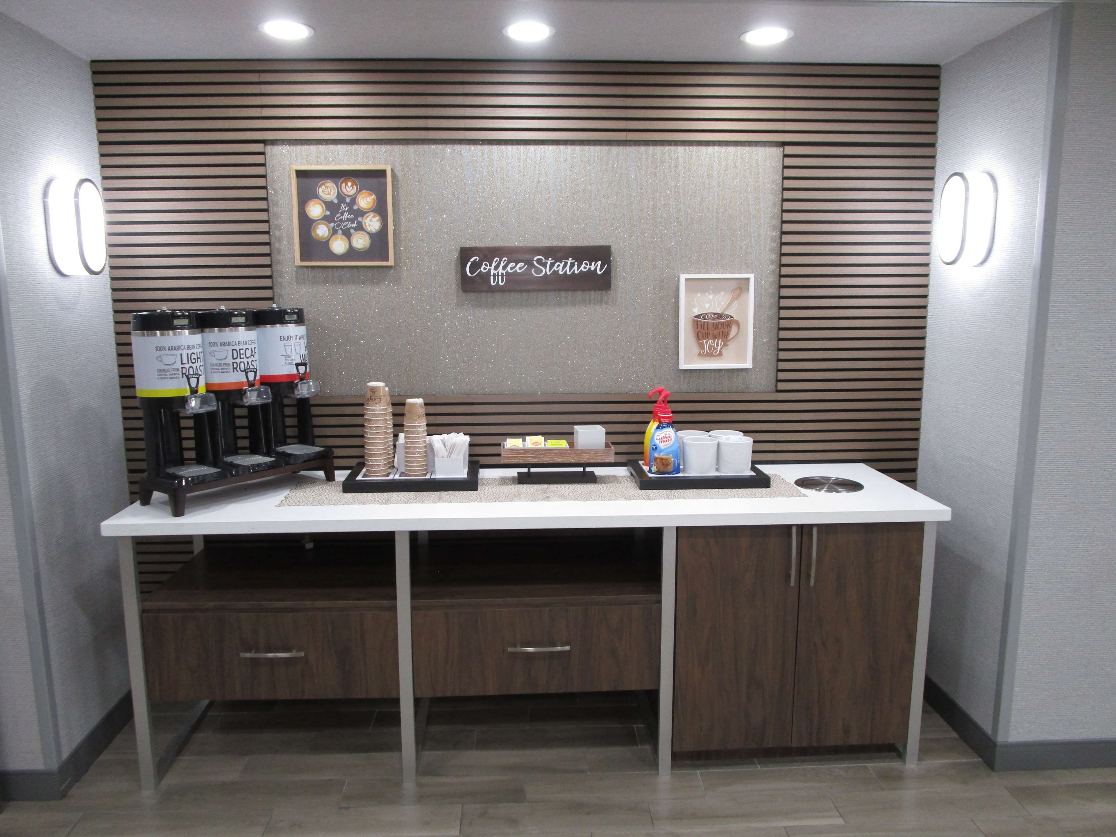 A coffee station with a sign reading 'Coffee Station' and a framed picture of coffee cups.