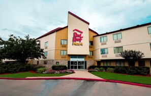 A Red Roof Plus hotel with a modern design, featuring a prominent entrance and a well-maintained exterior. - Red Roof Inn PLUS+ Houston - Energy Corridor (Houston)