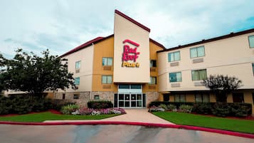 Un hotel Red Roof Plus con un diseño moderno, que cuenta con una entrada destacada y un exterior bien cuidado.