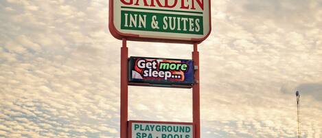 Letrero del Family Garden Inn & Suites que anuncia servicios como parque infantil, spa, piscinas y una tienda de conveniencia.