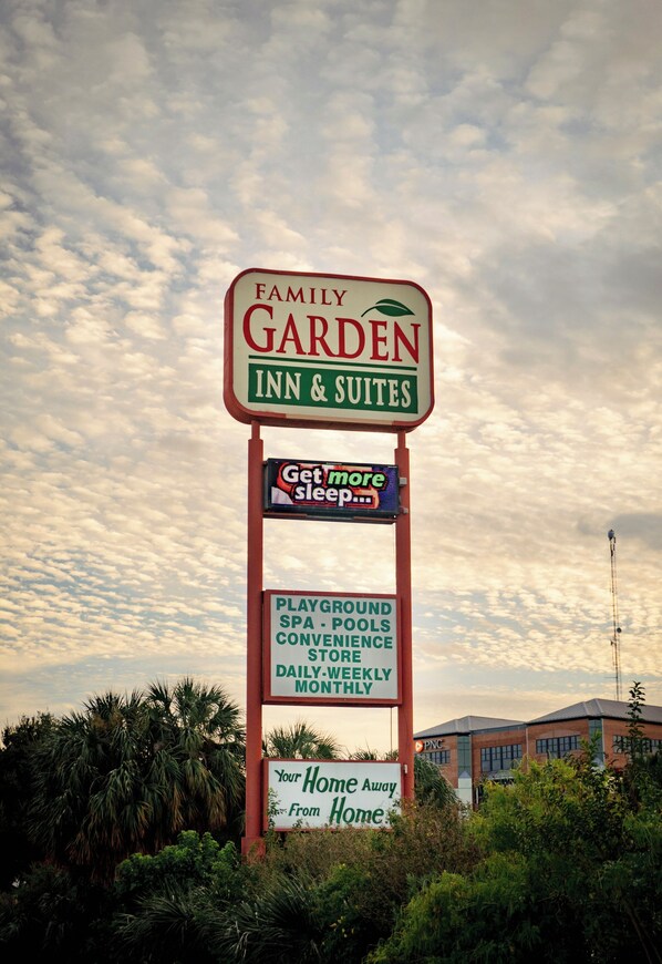 Letrero del Family Garden Inn & Suites que anuncia servicios como parque infantil, spa, piscinas y una tienda de conveniencia.