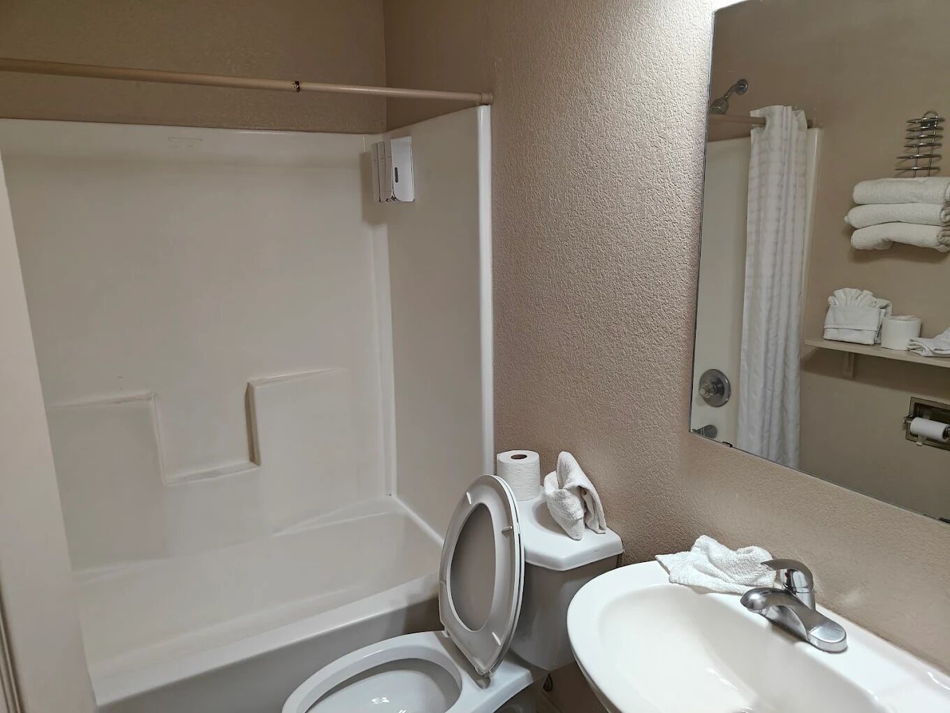 Une salle de bain avec des toilettes, un lavabo et une douche.