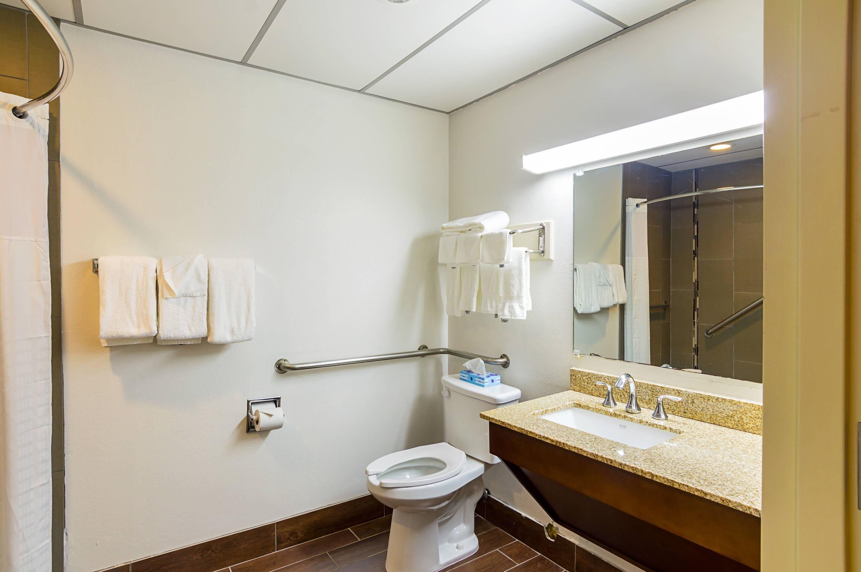 A bathroom with a toilet, sink, and shower area.