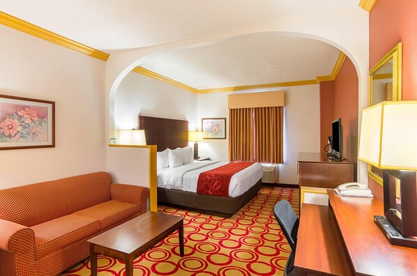 A hotel room with a bed, a sofa, a desk, a telephone, and a television. - Quality Suites Lubbock Southwest (Lubbock)