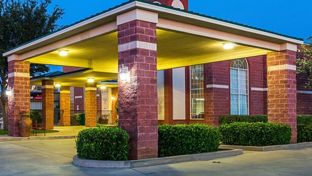 A brick building with a covered entrance and a car wash facility.