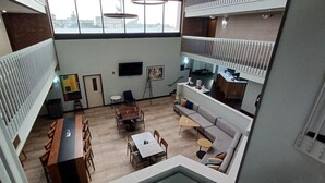 Un intérieur à plusieurs niveaux comprenant un coin repas, un espace salon et une petite cuisine.