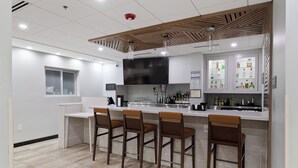 Une cuisine moderne avec un coin bar, des carreaux blancs et des éléments décoratifs en bois.