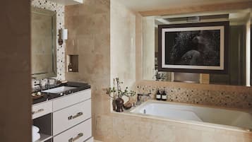 Un baño moderno con un espejo grande, una bañera y un lavabo.
