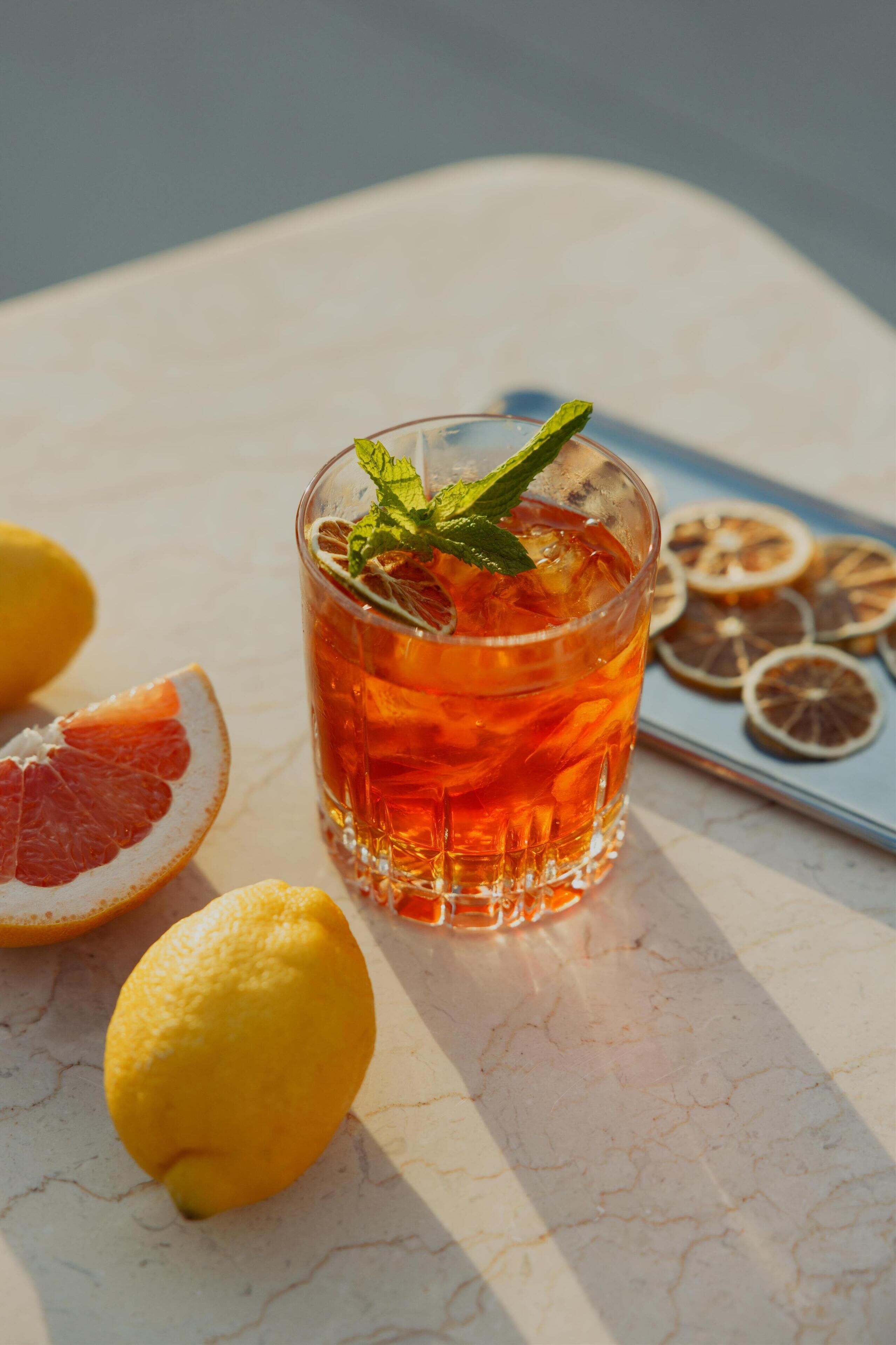 A glass of iced tea with a mint garnish on a marble table.