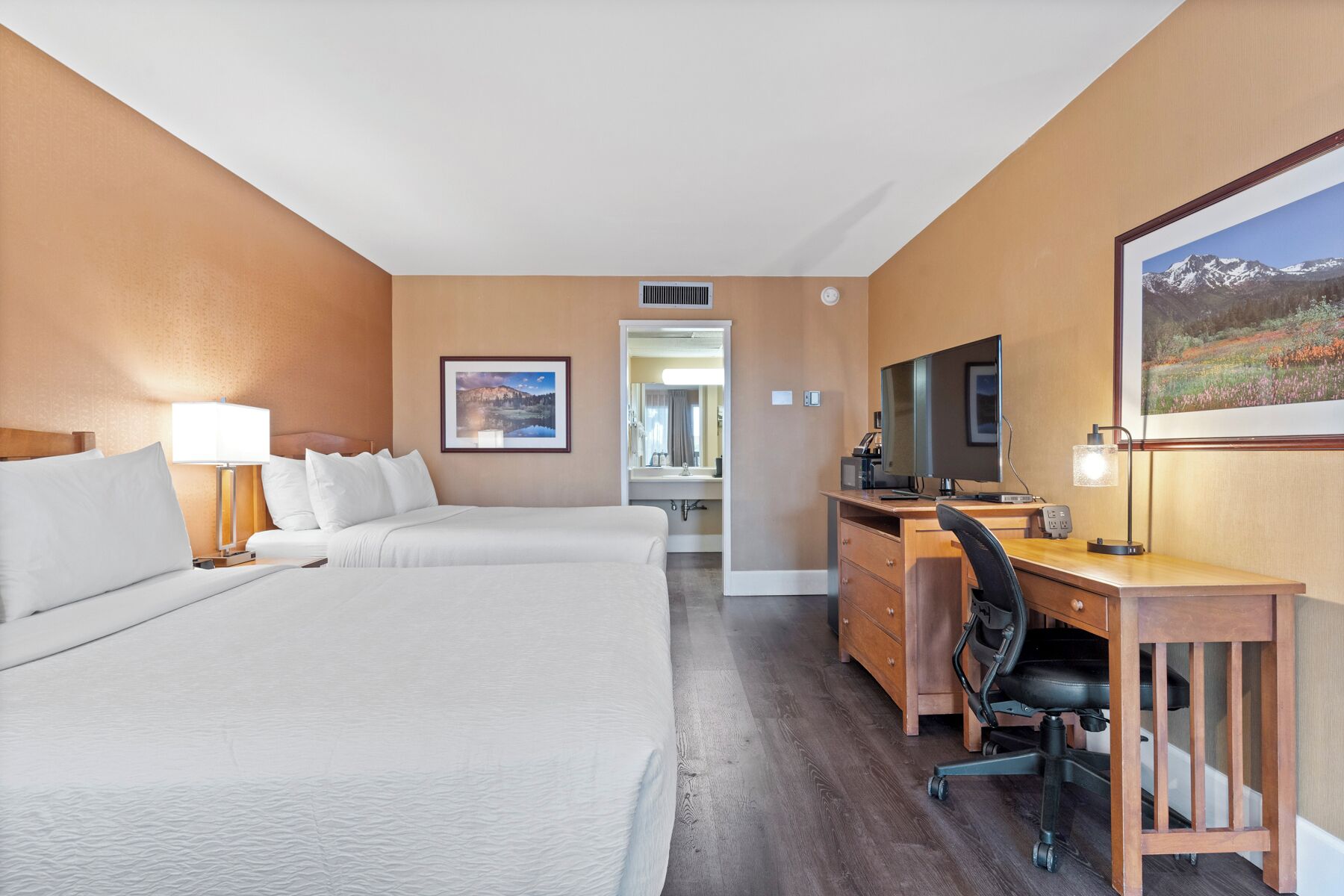 Una habitación de hotel con una cama grande, un escritorio con ordenador y televisión.