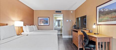 Una habitación de hotel con una cama grande, un escritorio con ordenador y televisión.