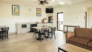 Una cocina moderna con comedor, sofá y televisor de pantalla plana.