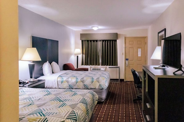 A hotel room with two beds, a desk, a chair, a TV, and a window with curtains. - Motel 6 Nacogdoches TX (Nacogdoches)
