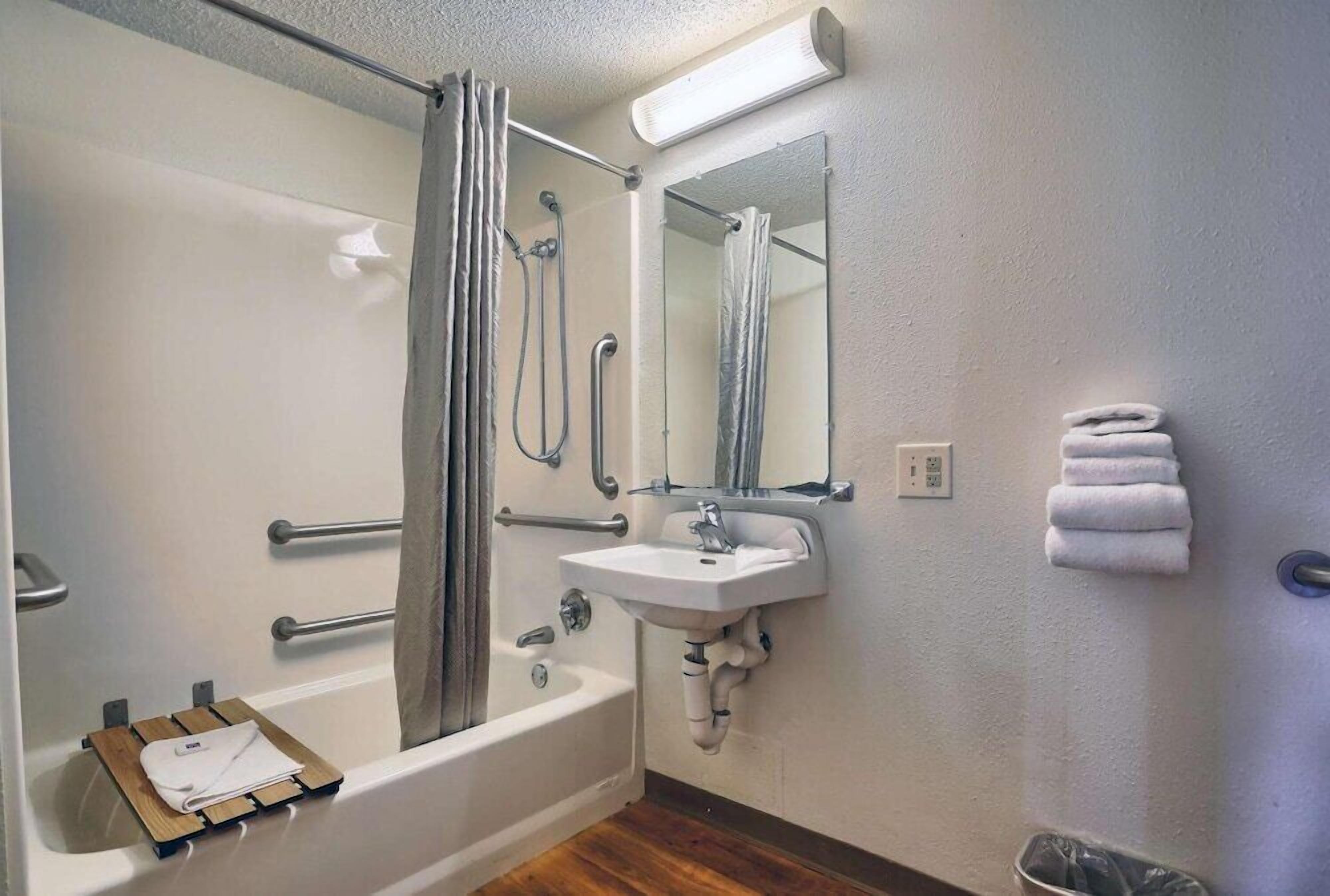 A bathroom with a bathtub, shower, and sink.