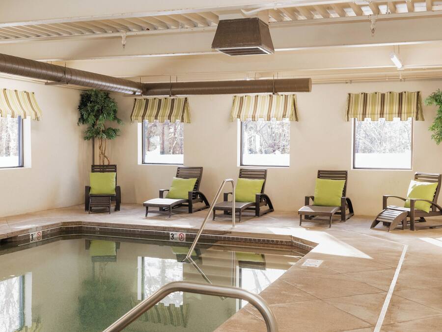 A pool area with lounge chairs and potted plants.