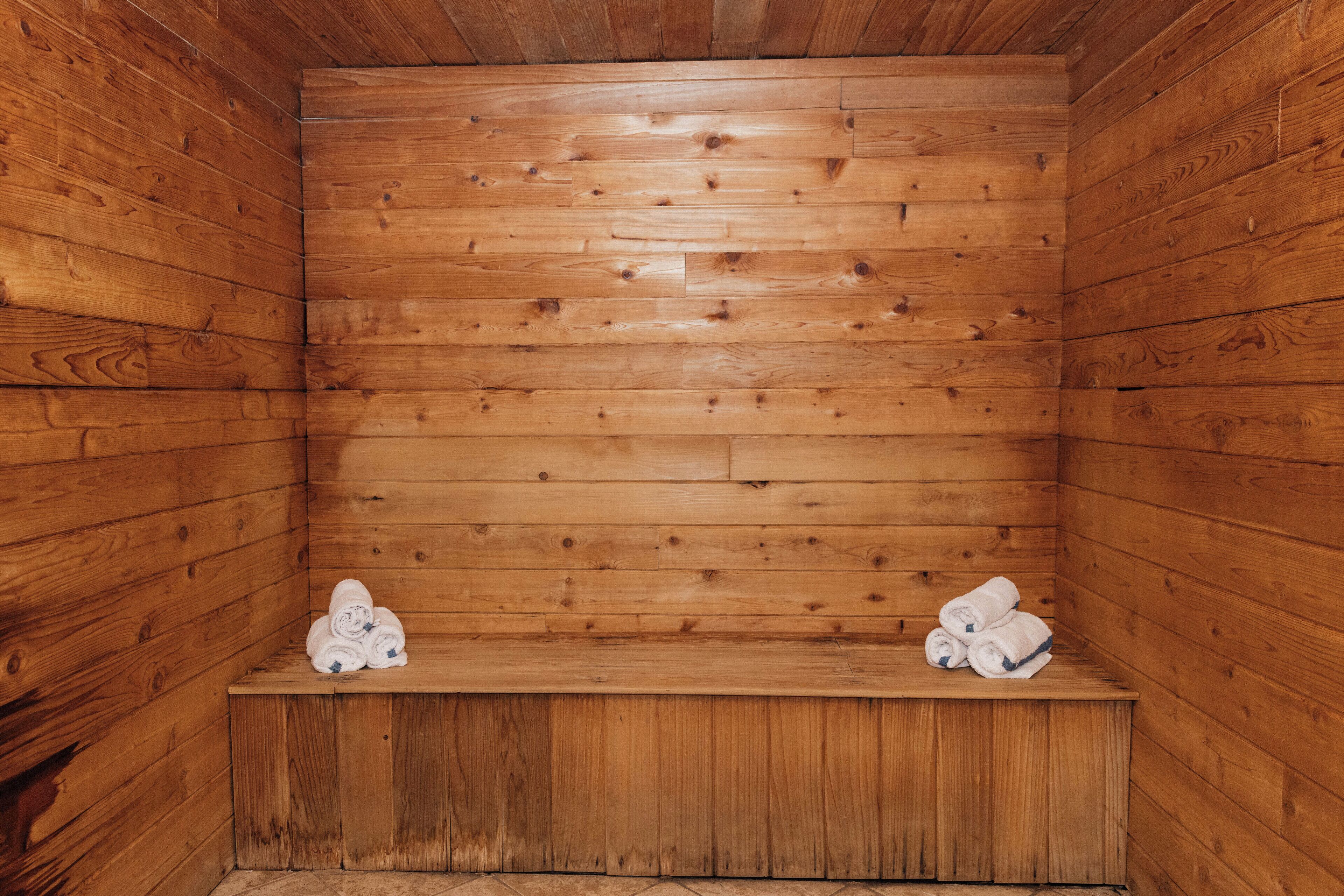 A wooden sauna with benches and towels.