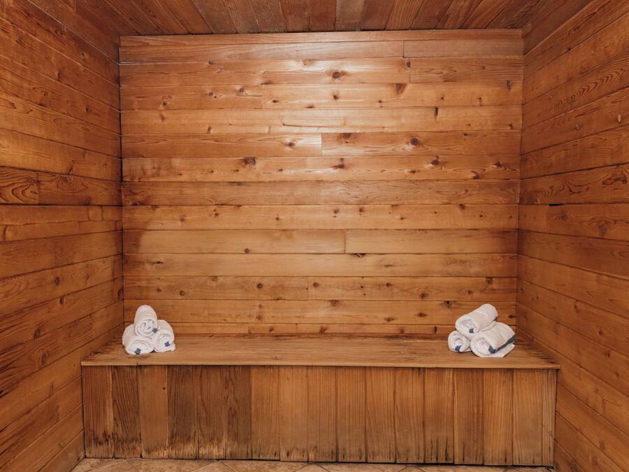 A wooden sauna with benches and towels.