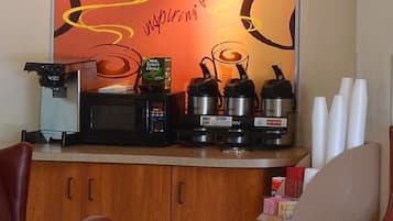 Pieni keittiönurkkaus, jossa on kahvinkeitin, mikroaaltouuni, vedenkeitin ja leivänpaahdin.