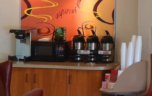 Una kitchenette equipada con cafetera, microondas, hervidor de agua y tostadora.