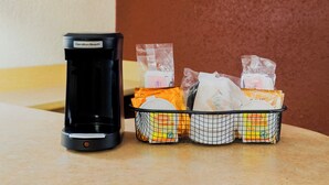 A Hamilton Beach commercial coffee maker and a basket with various packaged food items. - Red Roof Inn San Antonio - Airport (San Antonio)