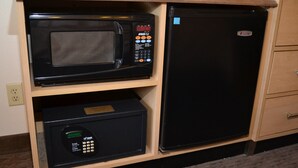 A compact kitchen with a microwave and a refrigerator built into a wooden cabinet. - Red Roof Inn San Antonio - Airport (San Antonio)
