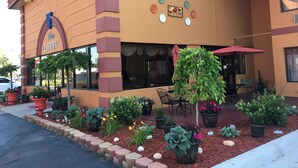 A building with a sign reading "Lobby" and a patio area with potted plants and outdoor seating.