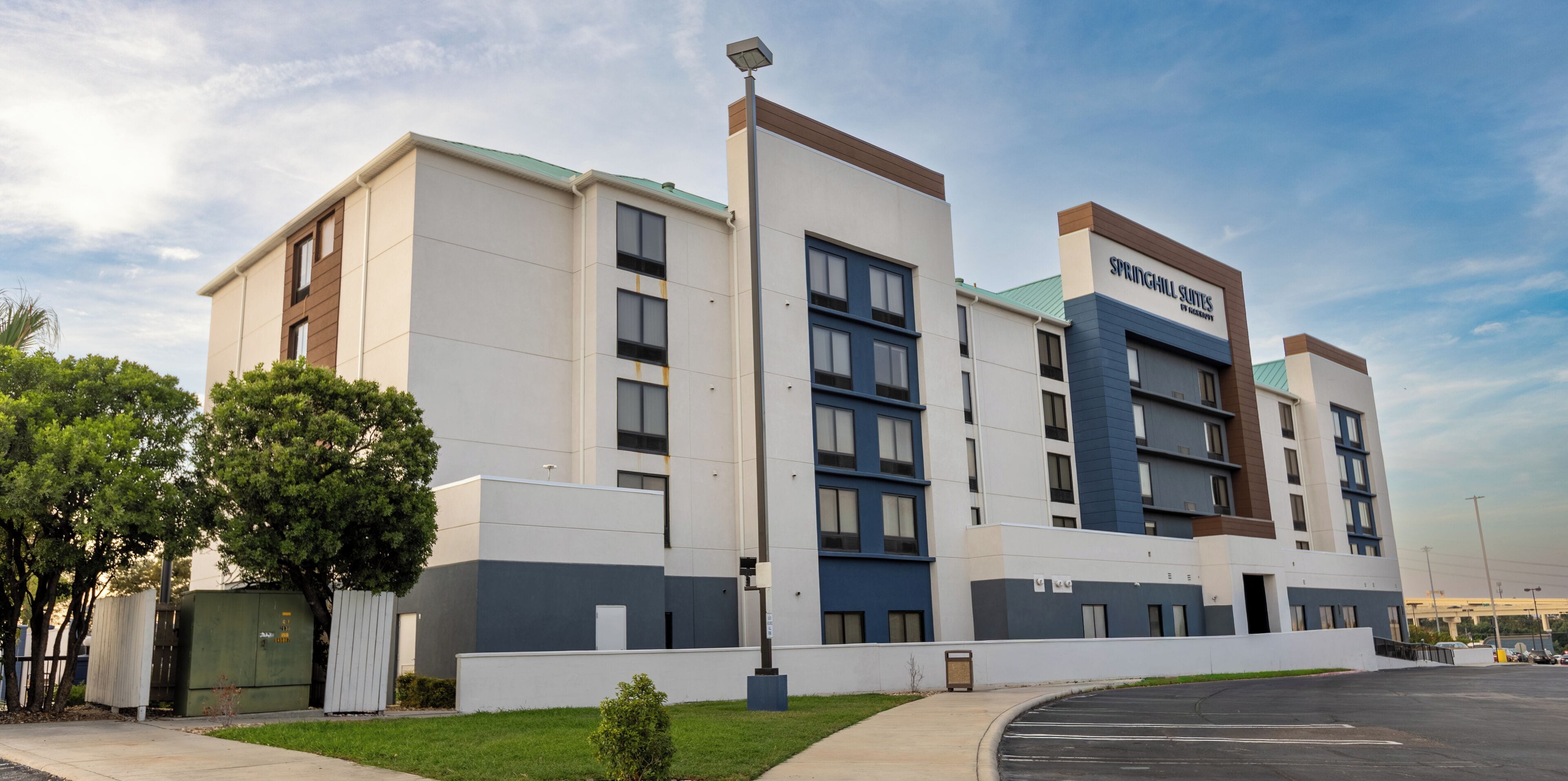 A modern hotel with a flat roof, multiple windows, and a sign for Springhill Suites.