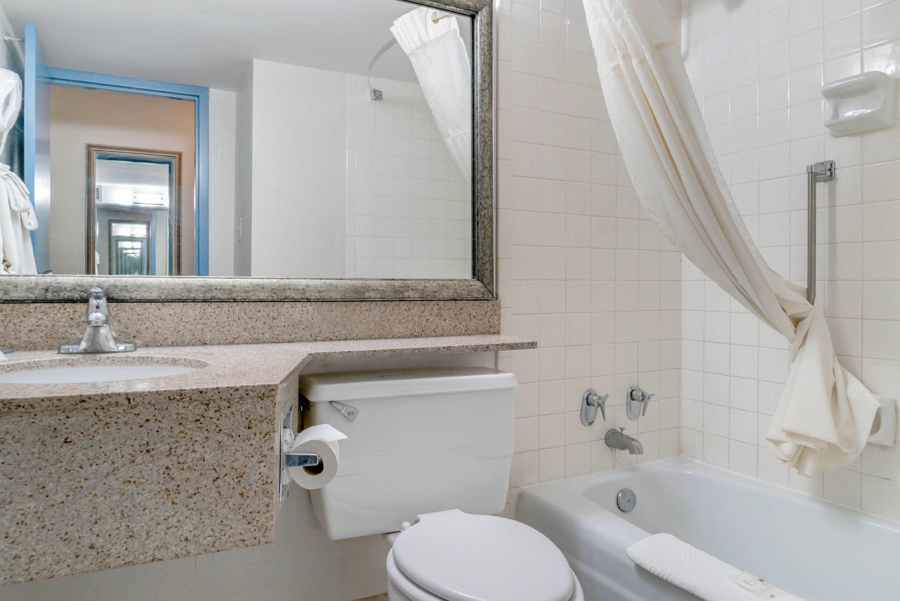 Un baño con lavamanos, inodoro y bañera.