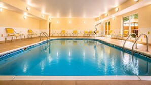 A swimming pool with chairs and a sunshade, surrounded by walls with recessed lighting. - Comfort Inn & Suites Texas City I-45 (Texas City)