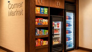A corner market with shelves stocked with snacks and a refrigerator containing beverages. - Comfort Inn & Suites Texas City I-45 (Texas City)