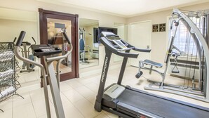 A fitness room with treadmills, a stationary bike, and a weight machine. - Super 8 by Wyndham Tyler TX (Tyler)