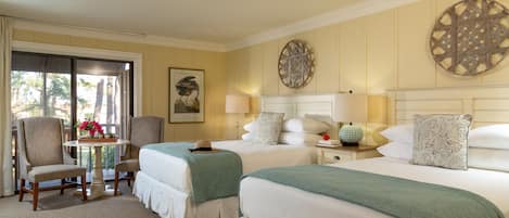 Une chambre d’hôtel avec deux lits, une table décorée de fleurs et une chaise.