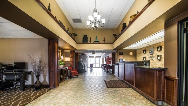 A hotel lobby with a reception desk, a chandelier, and a tiled floor. - Quality Inn & Suites Towanda (Towanda)