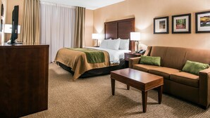 A hotel room with a bed, a sofa, a desk, and a TV. - Quality Inn & Suites Towanda (Towanda)