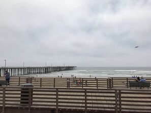 Un muelle que se adentra en el mar, con gente caminando.