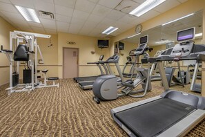 Un centre de remise en forme équipé de tapis de course, de vélos elliptiques et d'appareils de musculation.