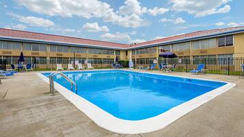 Una piscina al aire libre de temporada, sillones reclinables de piscina