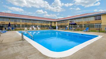 Una piscina al aire libre de temporada, sillones reclinables de piscina