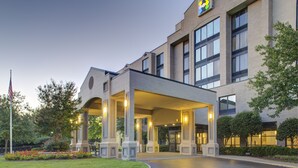 Ein Hotel mit überdachter Eingangspartie, großen Fenstern und einer Ziegel-Fassade.