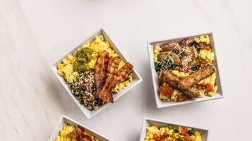 Five square dishes with scrambled eggs, various toppings, and toast.