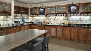 Una cocina moderna con armarios de madera, una isla de acero inoxidable y una barra desayunadora.
