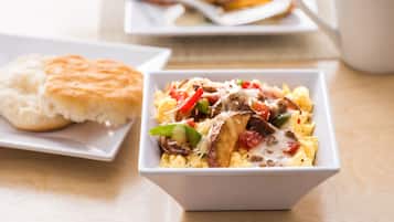 A breakfast dish with eggs, vegetables, and cheese on a white plate.