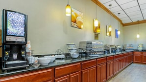 A hotel breakfast area with a coffee machine, bowls, and a display of eggs.