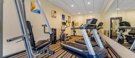 A gym with treadmills, elliptical machines, and weight machines.