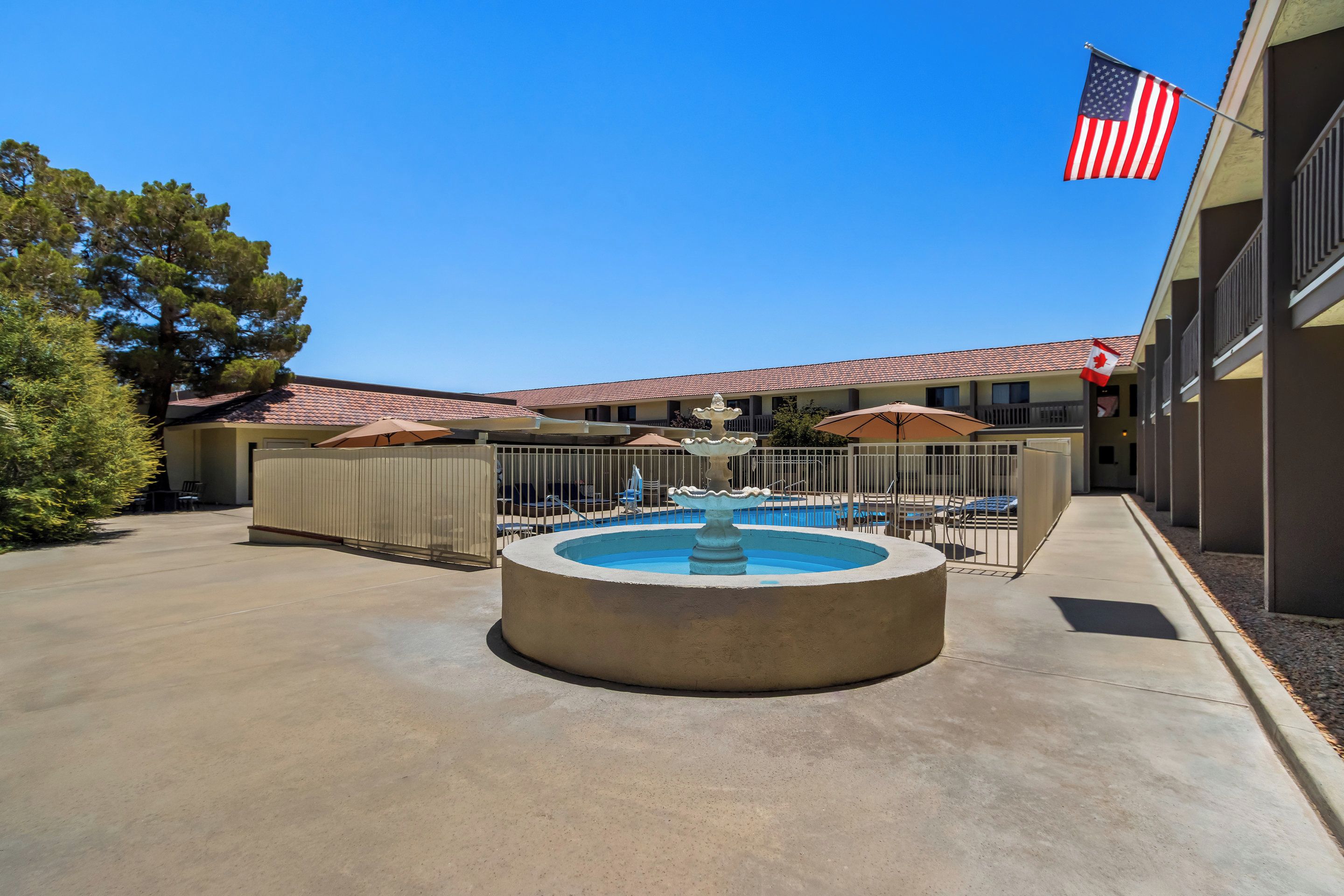 A courtyard with a central fountain, outdoor seating, and a pool area.