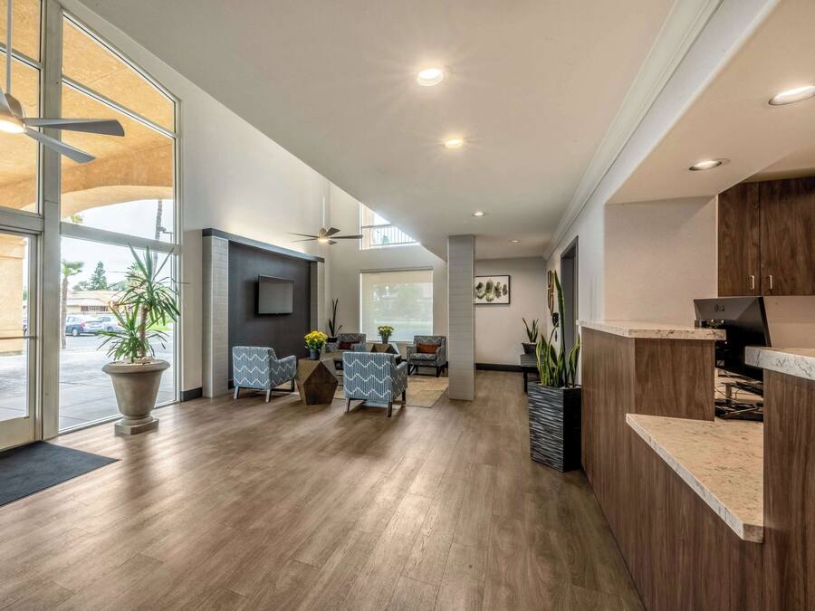 A spacious lobby with a reception desk, seating area, and large windows offering views of the outdoors.