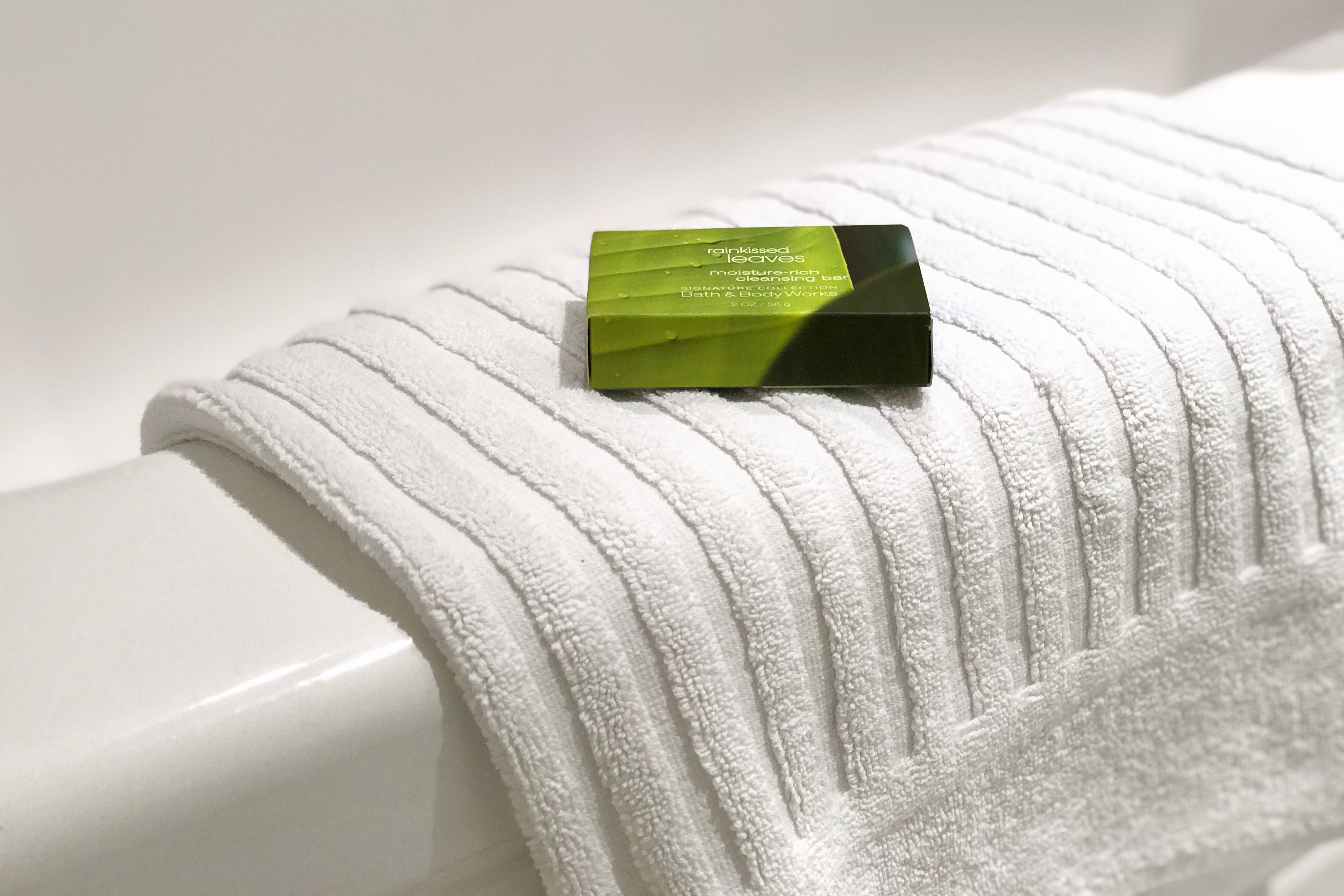 A white towel with a green and black object on it.
