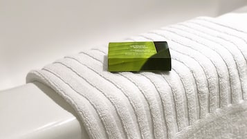 A white towel with a green and black object on it.
